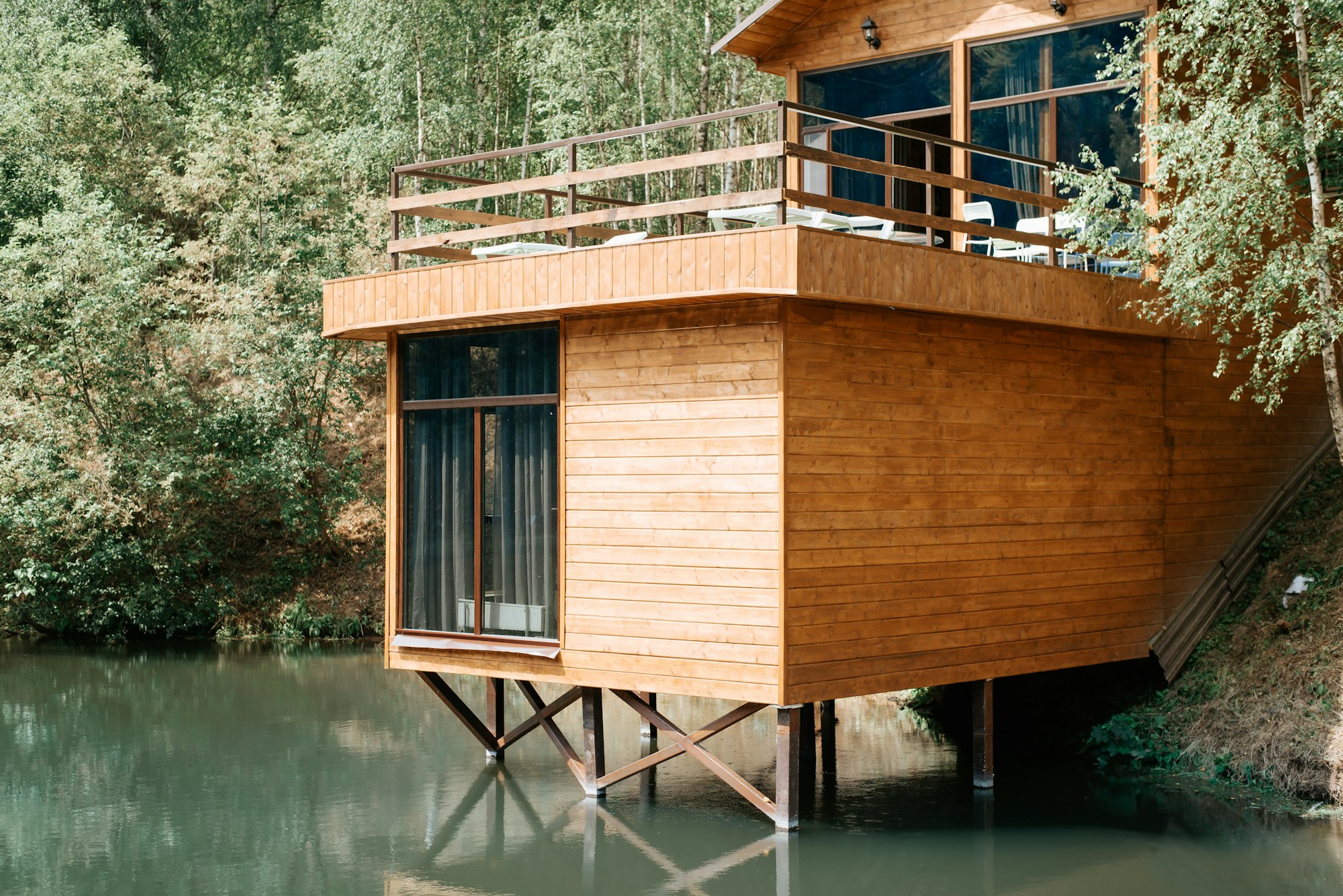 modern-wooden-loft-house-on-the-lake-close-up-exterior-of-a-country-house-with-a-balcony-cottage.jpg